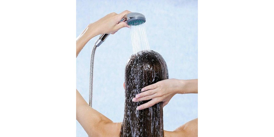 Kobieta myje włosy pod prysznicem.